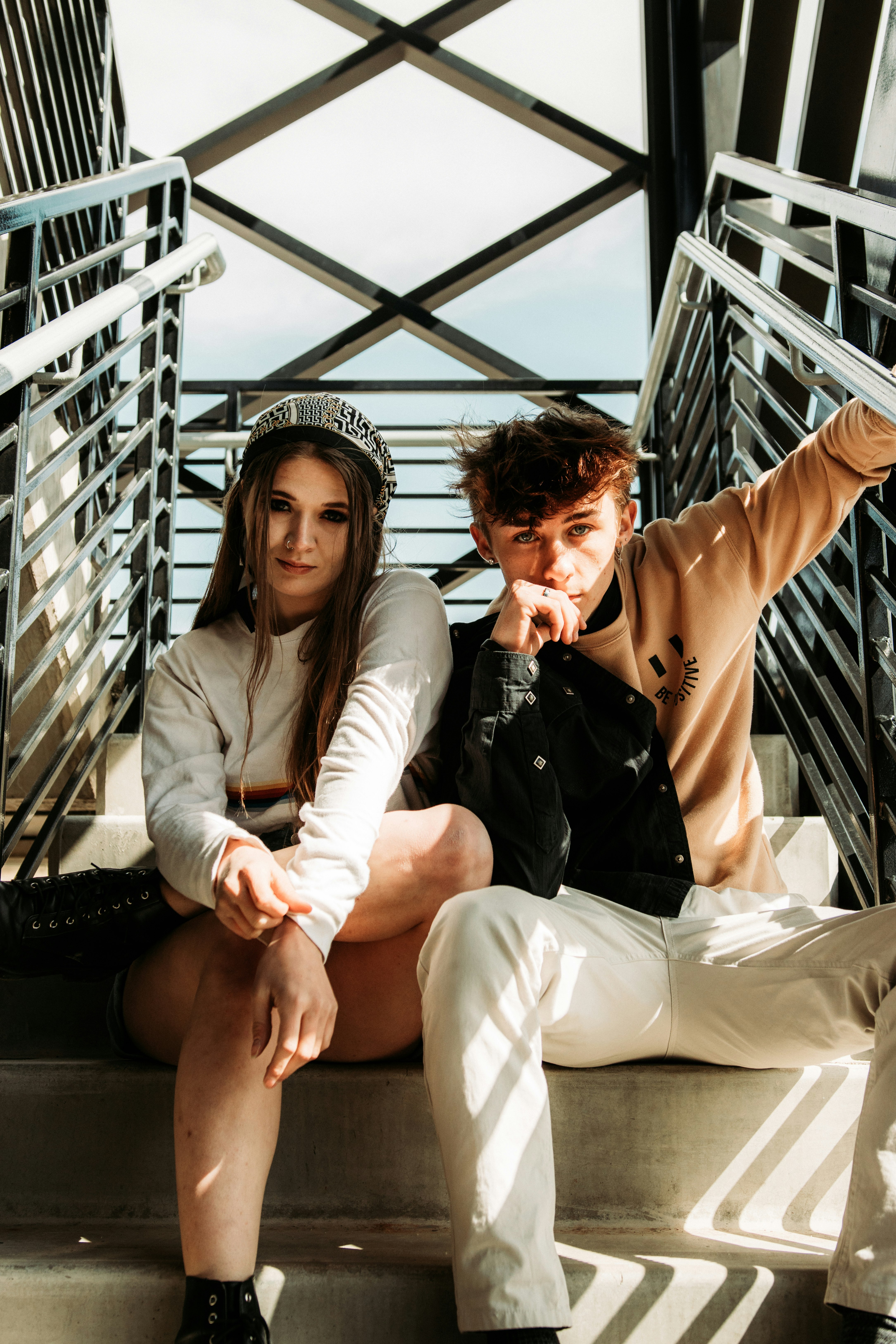 man and woman sitting on black metal stairs